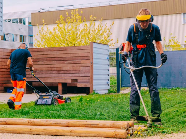 Opérateurs en action pour la tonte et le débroussaillage d’un espace collectif – Élagage Belfort
